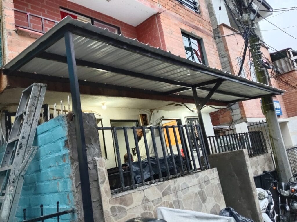 Instalación de cubierta metálica sobre acceso principal de vivienda en Belén, Medellín.