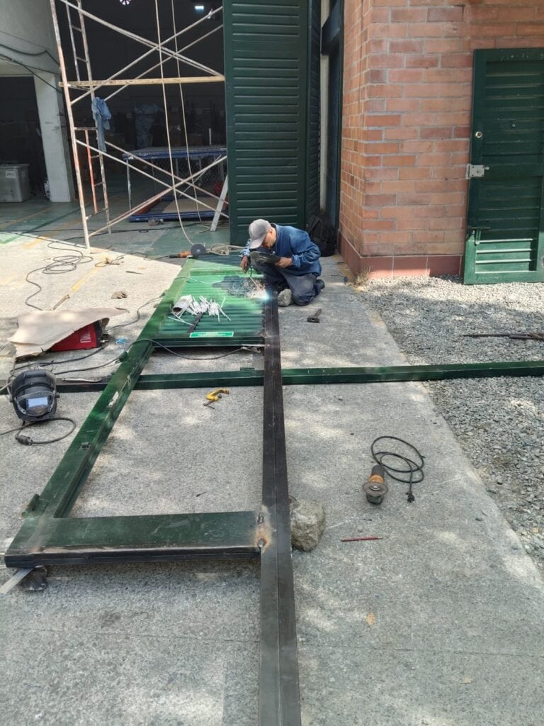 Perfil metálico deteriorado en portón corredizo reparado con trabajos de soldadura en Medellín